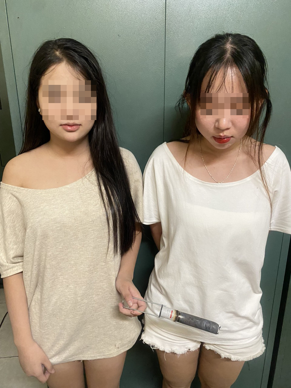 Hai cô gái mang theo vật giống pháo sáng để đốt trên đường. Hai cô gái mang theo vật giống pháo sáng để đốt trên đường.