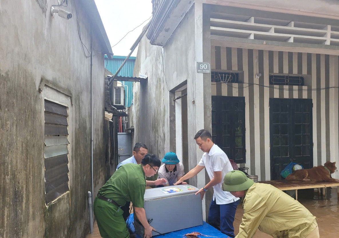 Công an quận cùng người dân hỗ trợ đưa người, di dời đồ đạc tránh nước ngập.