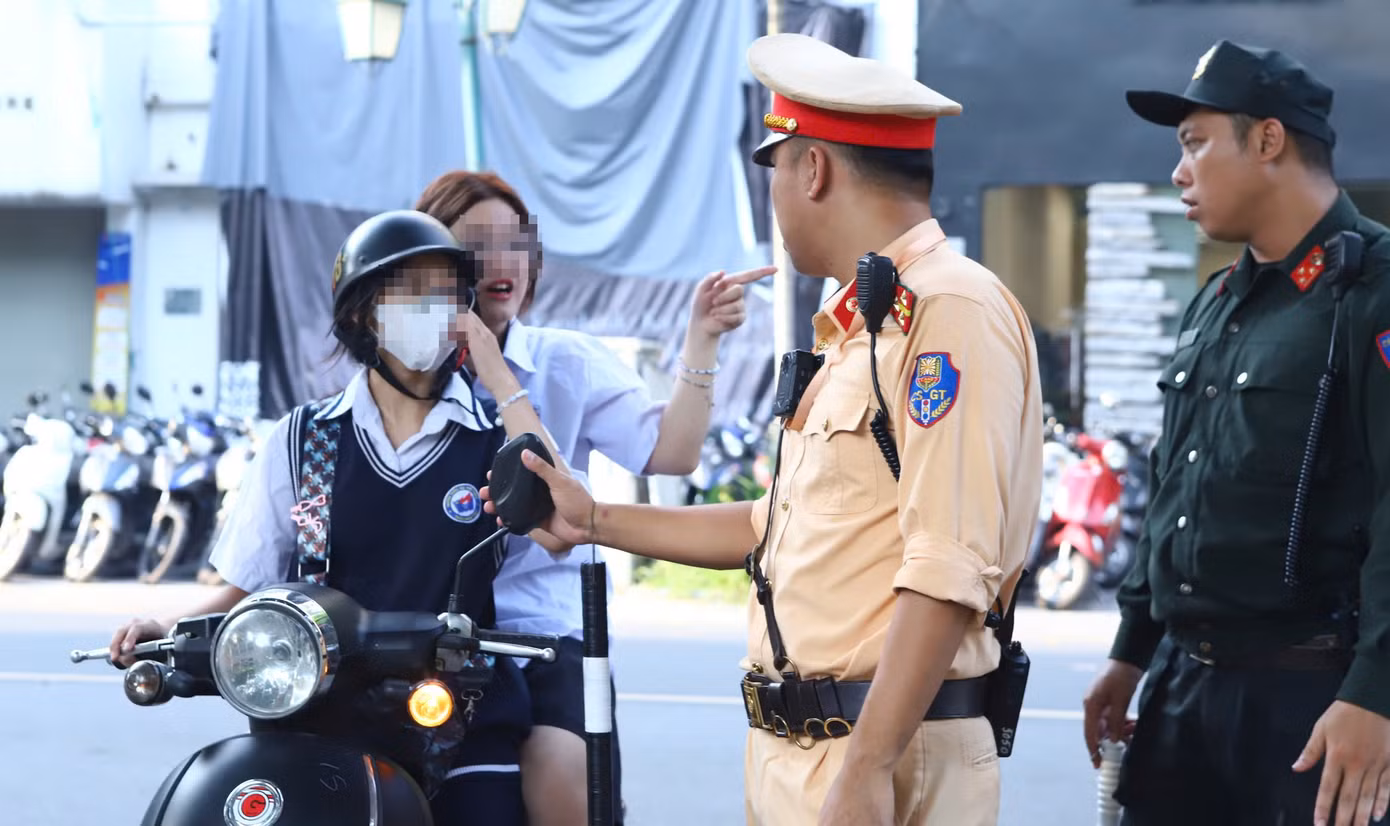 Nữ học sinh di chuyển trên đường không đội mũ bảo hiểm bị tổ công tác dừng kiểm tra.