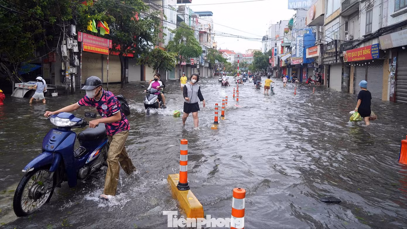 Trong khi trên phố Trần Nguyên Hãn ngập quãng đường dài, lực lượng chức năng dùng cảnh báo phản quang phân luồng và cảnh báo khu vực ngập sâu, có hố ga thoát nước.