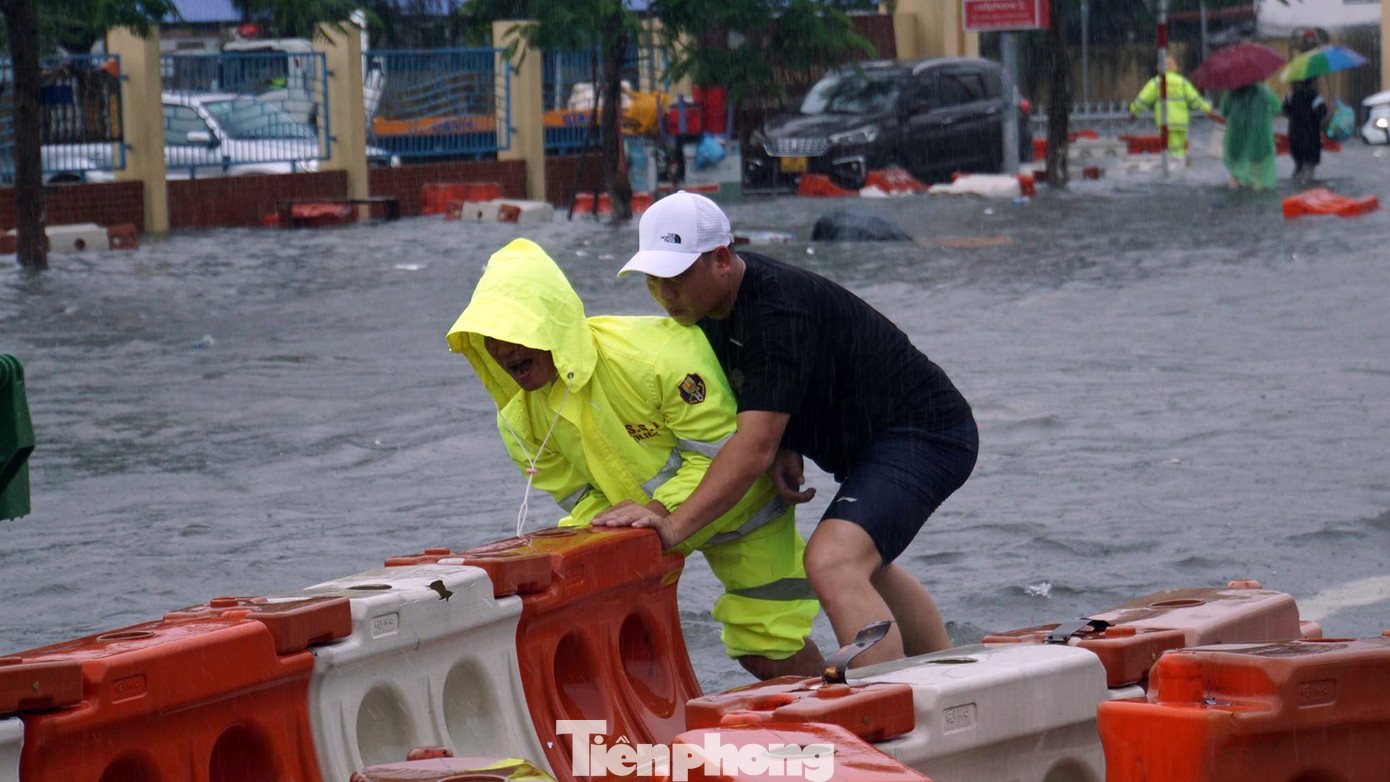 Cảnh sát chật vật di chuyển từng khối dải phân cách bị sóng đánh dạt. Cảnh sát chật vật di chuyển từng khối dải phân cách bị sóng đánh dạt.