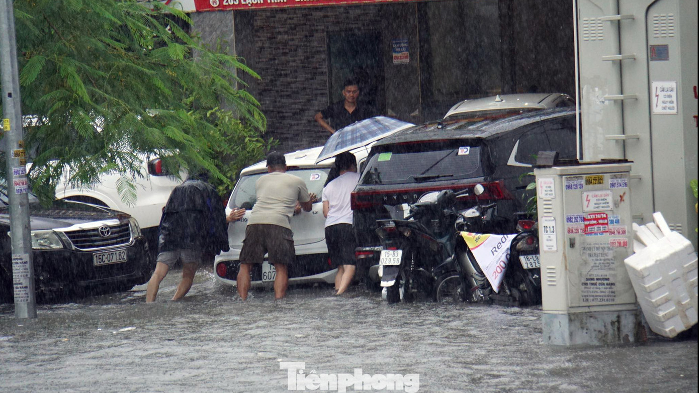 Cũng theo ghi nhận của PV, dọc tuyến phố Lạch Tray và phố Cát Bi, nhiều ô tô bị chết máy do nước ngập sâu. Trong ảnh, người dân đẩy ô tô lên vỉa hè phố Lạch Tray nhưng nước vẫn ngập nửa bánh xe. Cũng theo ghi nhận của PV, dọc tuyến phố Lạch Tray và phố Cát Bi, nhiều ô tô bị chết máy do nước ngập sâu. Trong ảnh, người dân đẩy ô tô lên vỉa hè phố Lạch Tray nhưng nước vẫn ngập nửa bánh xe.