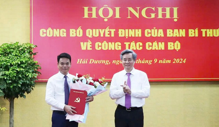 Ông Nguyễn Quang Dương, Phó Trưởng Ban Tổ chức Trung ương trao quyết định và tặng hoa cho ông Lê Ngọc Châu