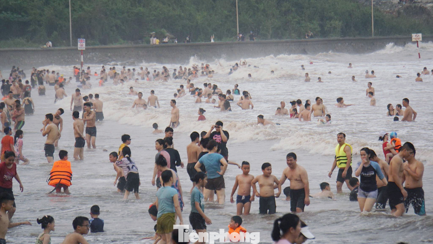 Dù nước đục ngầu, ngập rác nhưng rất đông người vẫn xuống tắm biển.