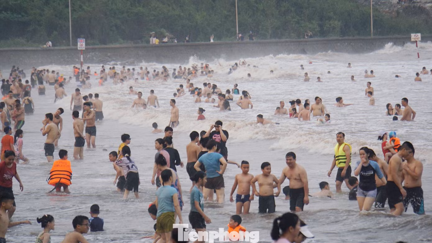 Dù nước đục ngầu, ngập rác nhưng rất đông người vẫn xuống tắm biển.