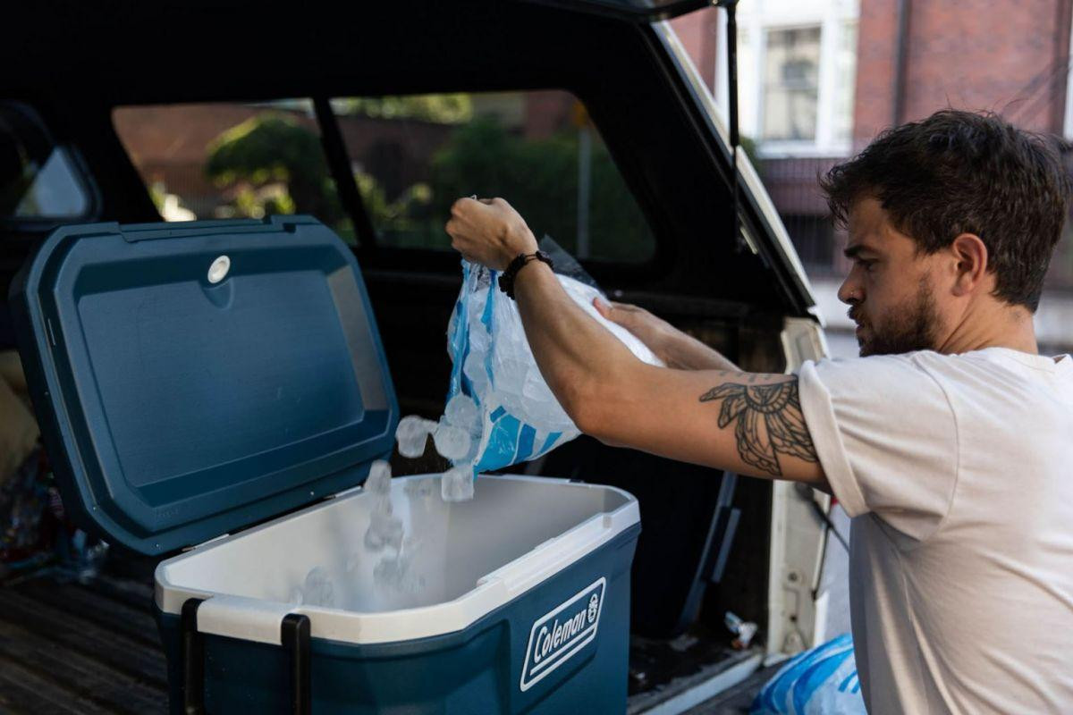 Một người đàn ông đổ đầy xô đá làm mát ở Portland. Ảnh: Bloomberg