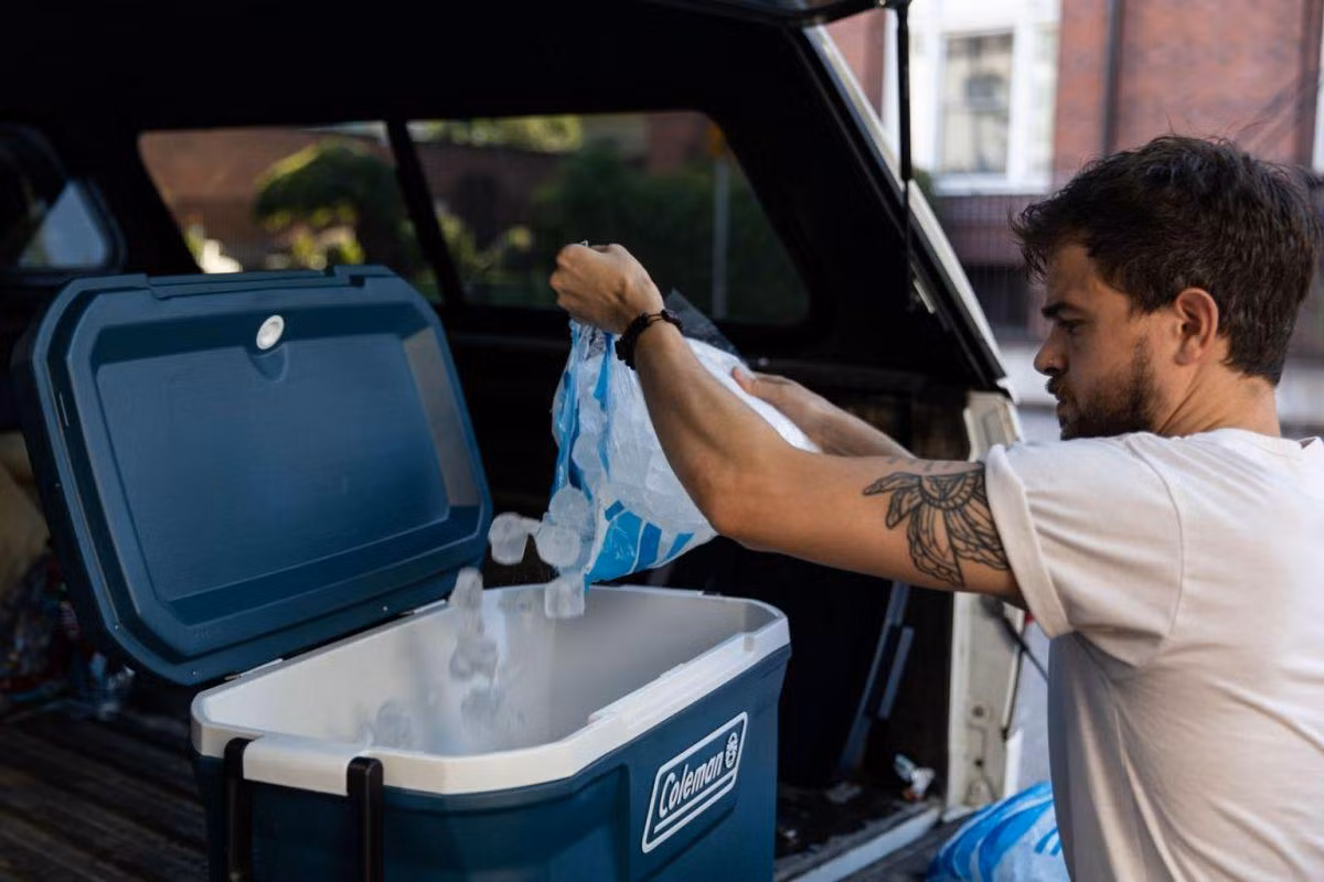Một người đàn ông đổ đầy xô đá làm mát ở Portland. Ảnh: Bloomberg