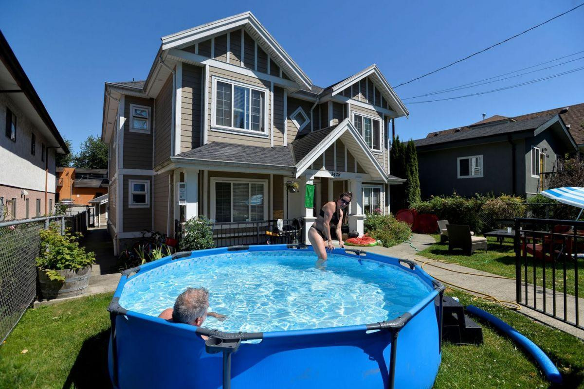 Người dân Vancouver dựng bể bơi trước cửa nhà. Ảnh: Reuters