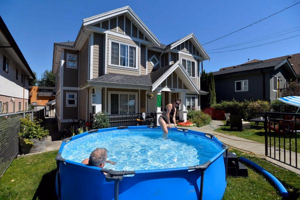 Người dân Vancouver dựng bể bơi trước cửa nhà. Ảnh: Reuters