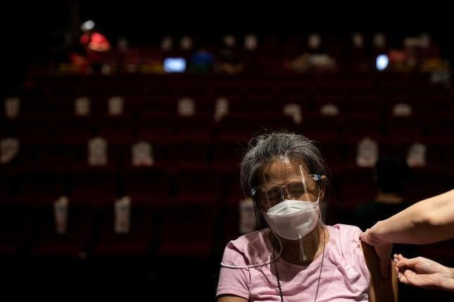 Một phụ nữ được tiêm vắc xin CoronaVac của Sinovac Biotech trong rạp chiếu phim ở San Juan (Philippines). Ảnh: Reuters Một phụ nữ được tiêm vắc xin CoronaVac của Sinovac Biotech trong rạp chiếu phim ở San Juan (Philippines). Ảnh: Reuters