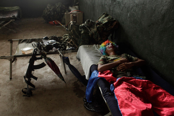 Một sỹ quan cảnh sát Panama trong trang phục chú hề đang nằm nghỉ trước buổi biểu diễn phục vụ quần chúng ở tỉnh Darien, giáp biên giới với Colombia