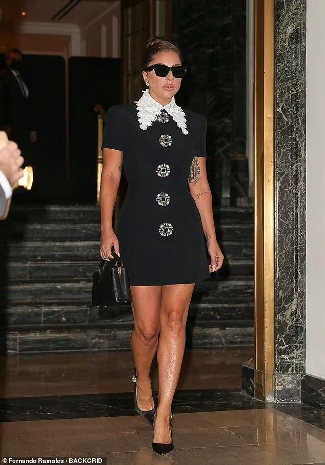 Ngày 30/7, Gaga giống như một quý cô thập niên 60 với váy đen có phần vai vuông và tay ngắn. Điểm nhấn là cổ váy trắng thêu hoa và hàng cúc bản lớn. Cô đi giày đen hở gót và xách túi &quot;ton-sur-ton&quot;. Dĩ nhiên, mắt kính là phụ kiện không thể thiếu.