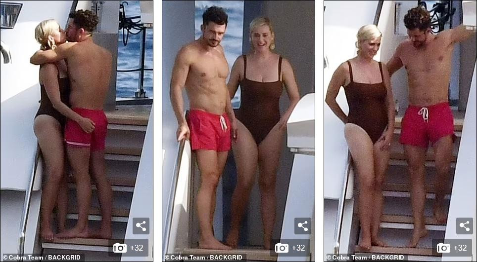 Nữ ca sĩ &quot;Roar&quot; mặc đồ bơi một mảnh màu nâu đơn giản. Trong khi, vị hôn phu hơn 7 tuổi nổi bật hơn với quần bơi màu đỏ, khoe cơ thể rắn rỏi, săn chắc ở tuổi 44.