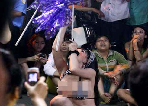 Ca sĩ chuyển đổi giới tính mặc bikini trình diễn trong một đám tang trước sự cổ vũ của đông đảo người xem. Ảnh: YM. 