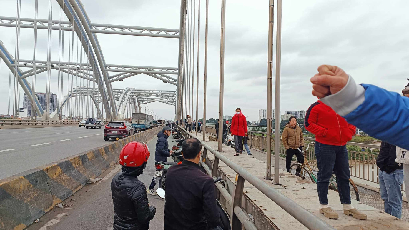 Nhiều người dân theo dõi sự việc trên cầu. Nhiều người dân theo dõi sự việc trên cầu.