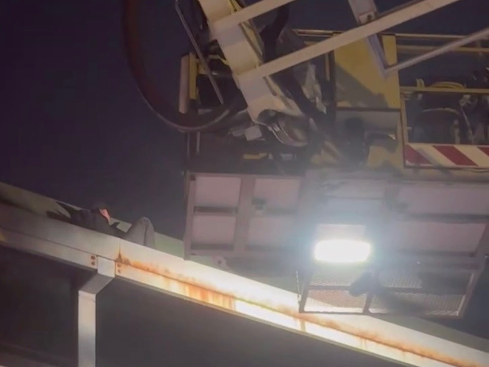 Người đàn ông nằm trên nóc cầu vượt.