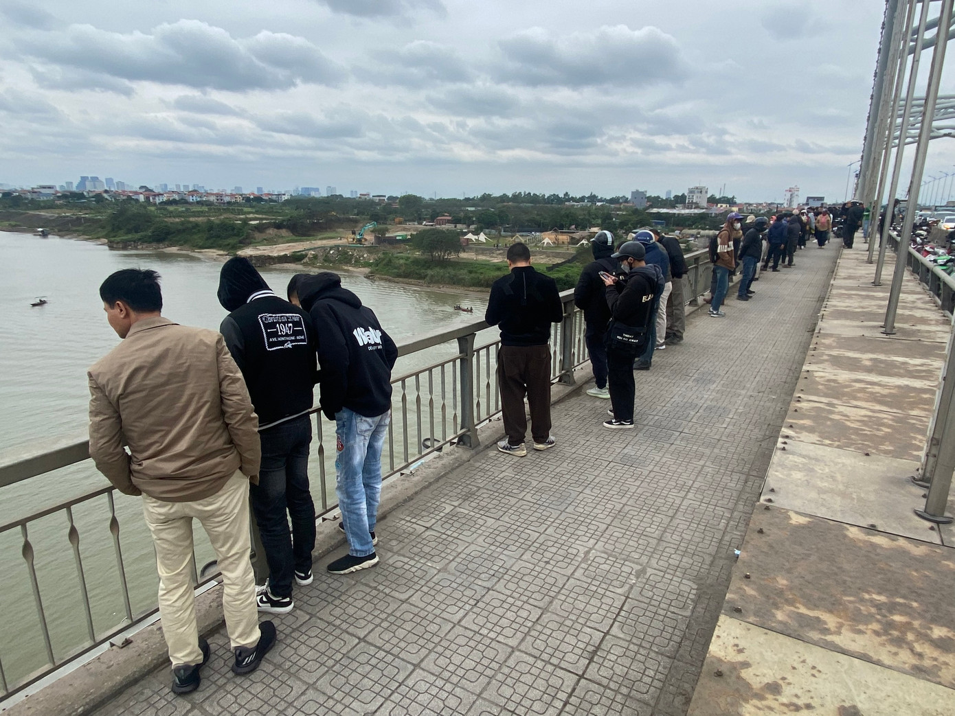 Nhiều người dân hiếu kỳ đứng trên cầu Đông Trù theo dõi sự việc. Nhiều người dân hiếu kỳ đứng trên cầu Đông Trù theo dõi sự việc.