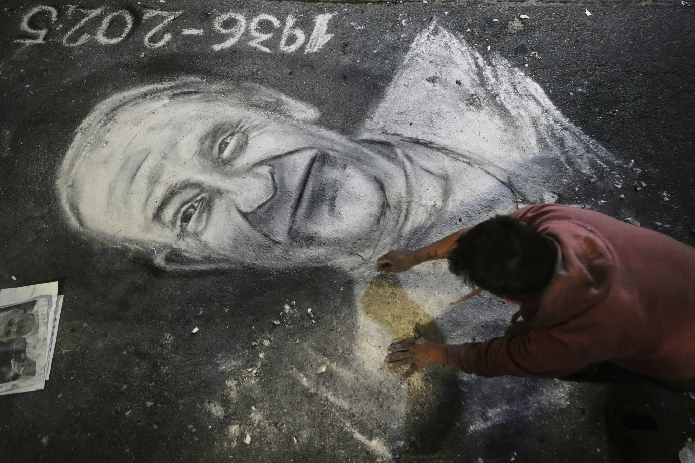 Một nghệ sĩ đường phố đang vẽ chân dung cố Giáo hoàng Francis bên ngoài nhà thờ lớn ở Buenos Aires, Argentina. Ảnh: AP.