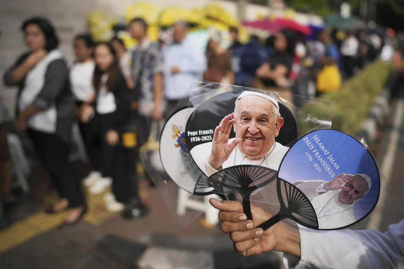 Những người bán hàng ở Indonesia bán móc chìa khóa và quạt có hình ảnh của Giáo hoàng Francis cho du khách. Ảnh: AP.