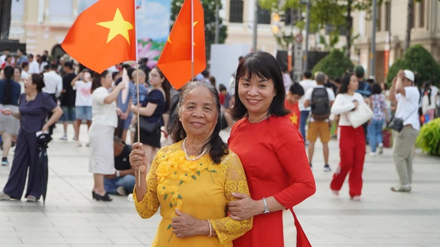 Bà Trần Thị Lộng (áo dài vàng) cùng con gái tại Phố đi bộ Nguyễn Huệ