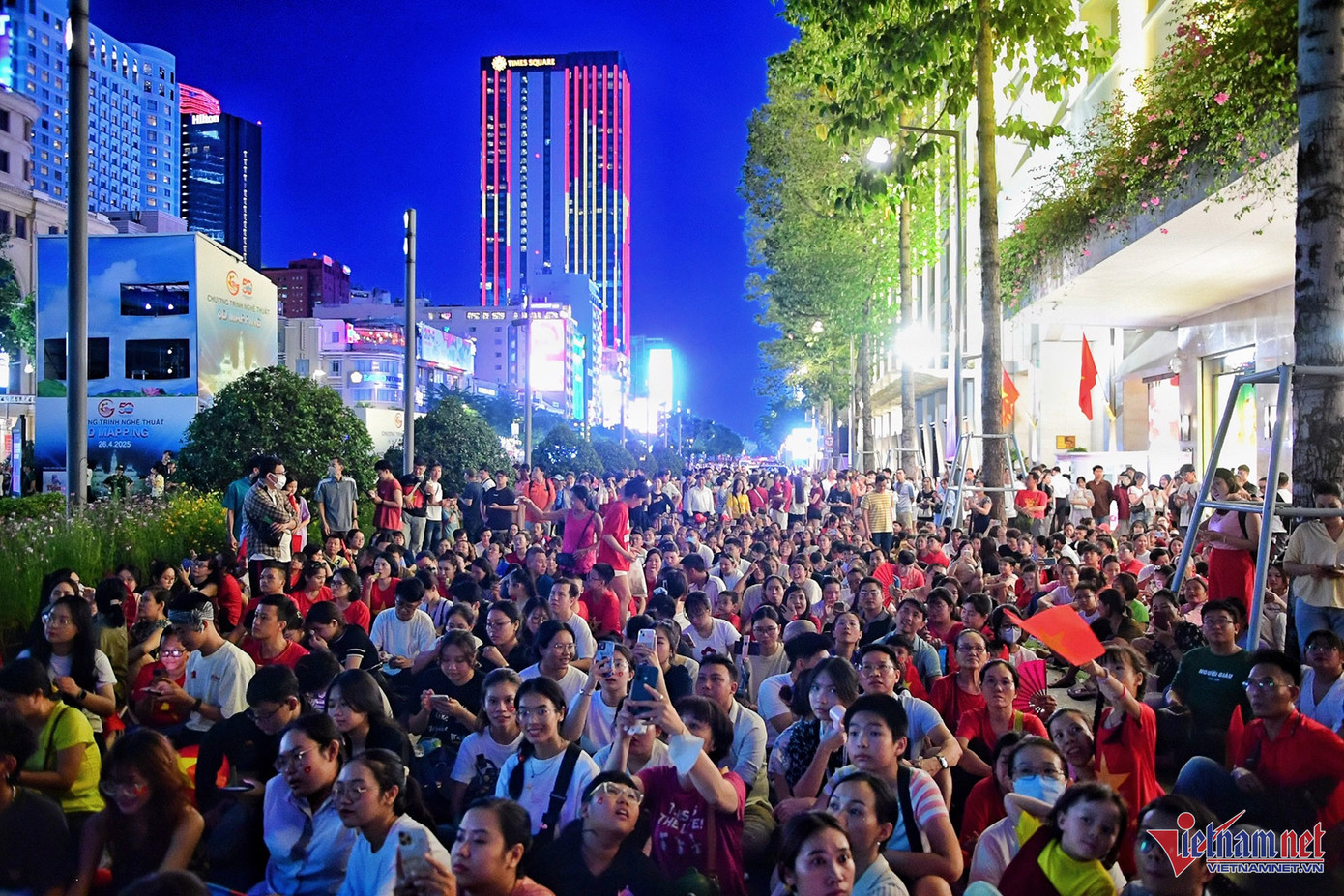 Người dân và du khách ngồi kín lòng đường Nguyễn Huệ chờ xem màn trình diễn 3D mapping.