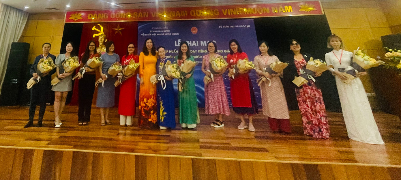 Thứ trưởng Bộ Ngoại giao Lê Thị Thu Hằng (áo vàng) tặng hoa đại diện các nước có giáo viên về tham dự khóa tập huấn. (Ảnh: L.A)