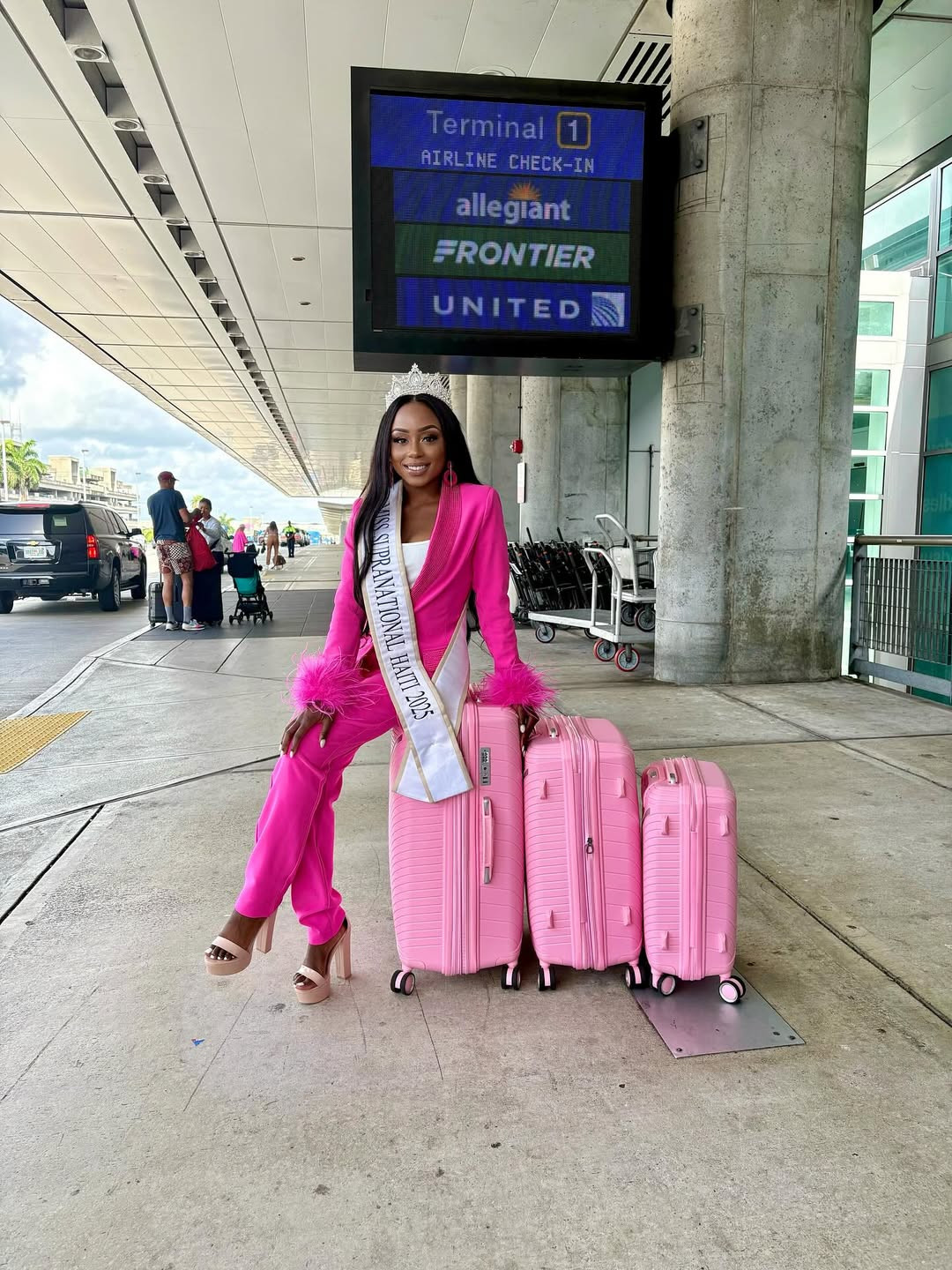 Đại diện Haiti - Sklouchere Pierre - nổi bật ở sân bay với trang phục và valy tông màu hồng.