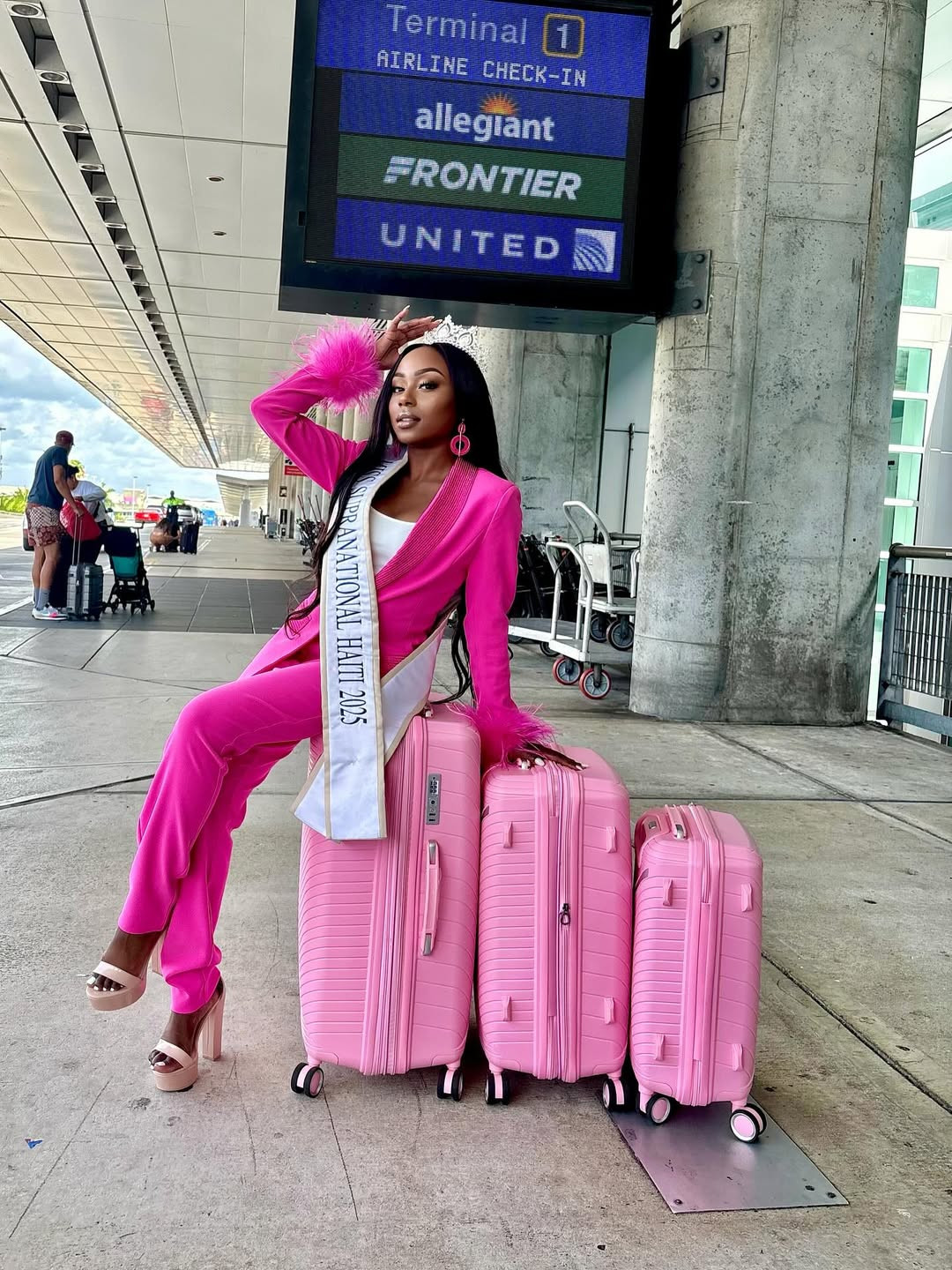 Đại diện Haiti - Sklouchere Pierre - nổi bật ở sân bay với trang phục và valy tông màu hồng.