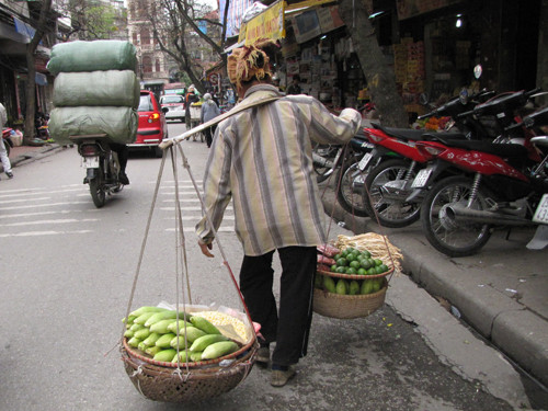 Gánh hàng lại thêm nặng trĩu trên vai họ. Ảnh: Trường Phong