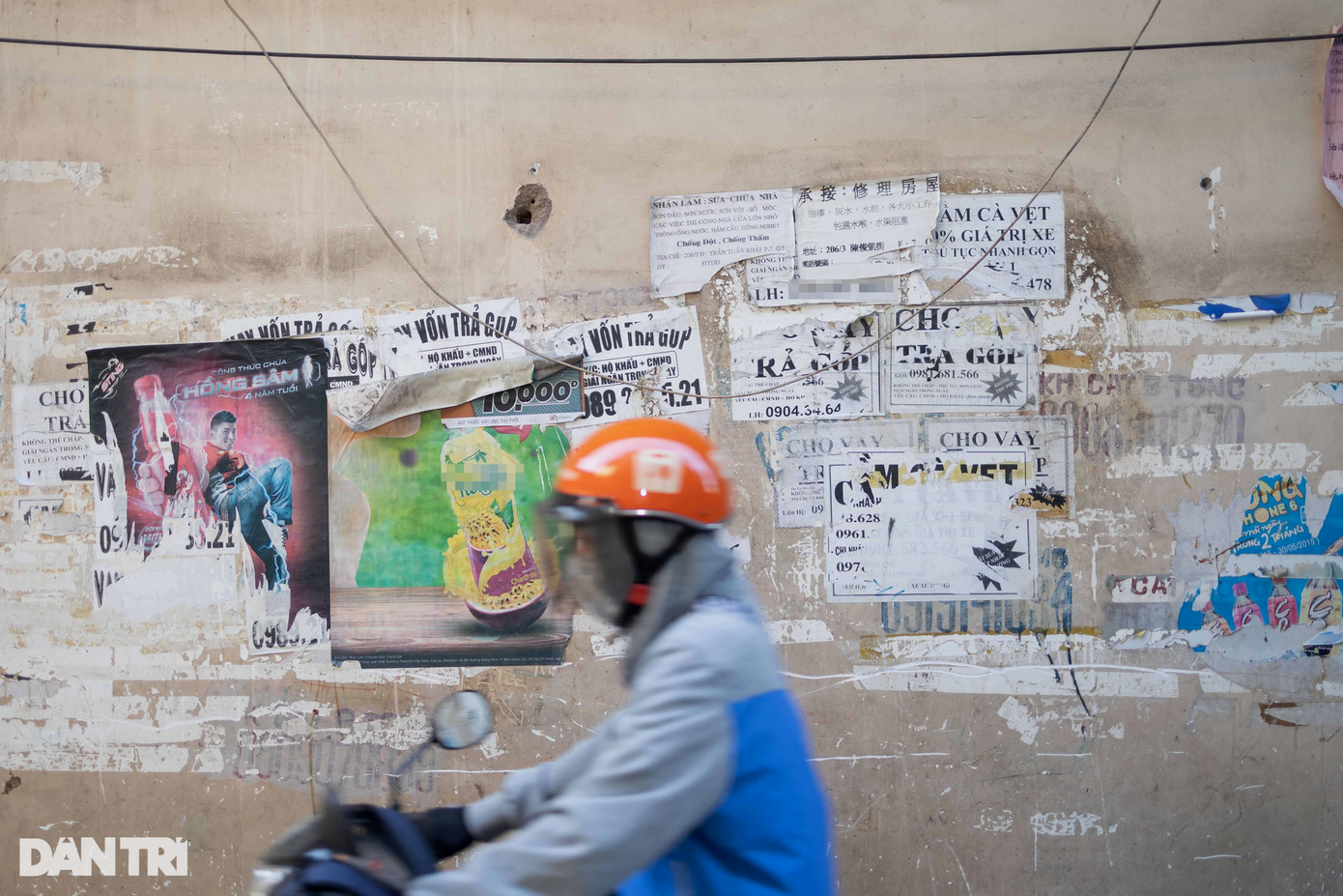 Ngoài các cột điện và trụ điện, các mảng tường cũng là nơi lý tưởng cho việc dán bậy. Trong ảnh, một con hẻm trên đường Trần Hưng Đạo (phường 7, quận 5) tràn ngập các tờ giấy quảng cáo về dịch vụ như "cho vay trả góp" và "cầm cà vẹt xe".