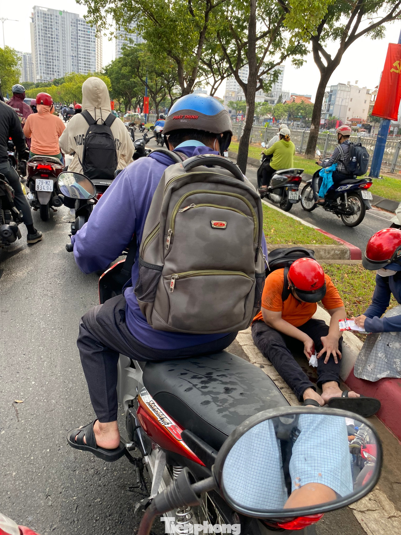 Mặt đường Võ Văn Kiệt (quận 1) trơn trượt do mưa khiến một số người điều khiển xe máy bị té ngã.