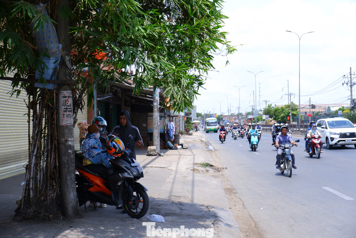 Anh Lê Tam Long (31 tuổi) cho biết, anh cùng vợ và con từ Vĩnh Long trở lại TPHCM sau kỳ nghỉ lễ. Gia đình khởi hành bằng xe máy từ lúc 8 giờ sáng. Đến khoảng 11 giờ 30 là đến được cửa ngõ vào TPHCM. &quot;Nắng quá gắt, từ sáng khoảng 9 giờ là nắng đã gắt, chúng tôi phải dừng chân liên tục để nghỉ ngơi nên mất nhiều thời gian hơn bình thường&quot; - anh Long kể. Trong ảnh: Một gia đình dừng chân tại bóng mát ven đường ở huyện Bình Chánh (TPHCM) để nghỉ ngơi sau hành trình dài.