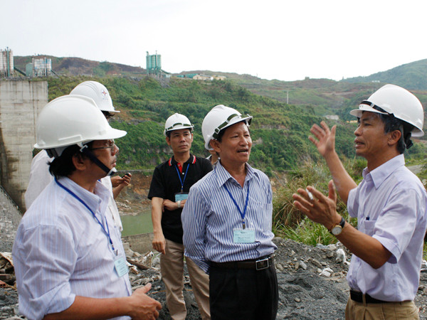 Ông Trần Văn Hải (phải) giải thích với các chuyên gia về thiết kế đập Sông Tranh 2 