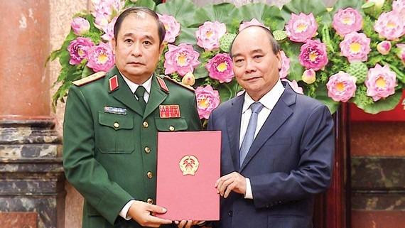 Chủ tịch nước Nguyễn Xuân Phúc trao Quyết định thăng quân hàm Thượng tướng cho ông Phùng Sĩ Tấn. Ảnh: SGGP