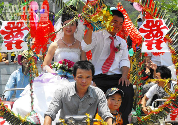 Cô dâu và chú rể hạnh phúc trên chiếc xe hoa là chiếc xe công nông càng tự chế được trang trí rất đẹp mắt