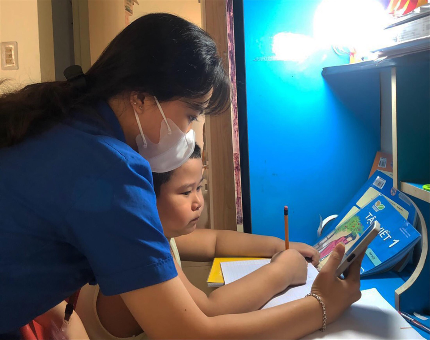 Bạn Võ Thùy Loan (thành viên Đội IT áo xanh của Đoàn phường Thuận Phước, quận Hải Châu) hỗ trợ em Phạm Võ Tiến Minh, học sinh lớp 1/4, Trường Tiểu học Võ Thị Sáu, học trực tuyến