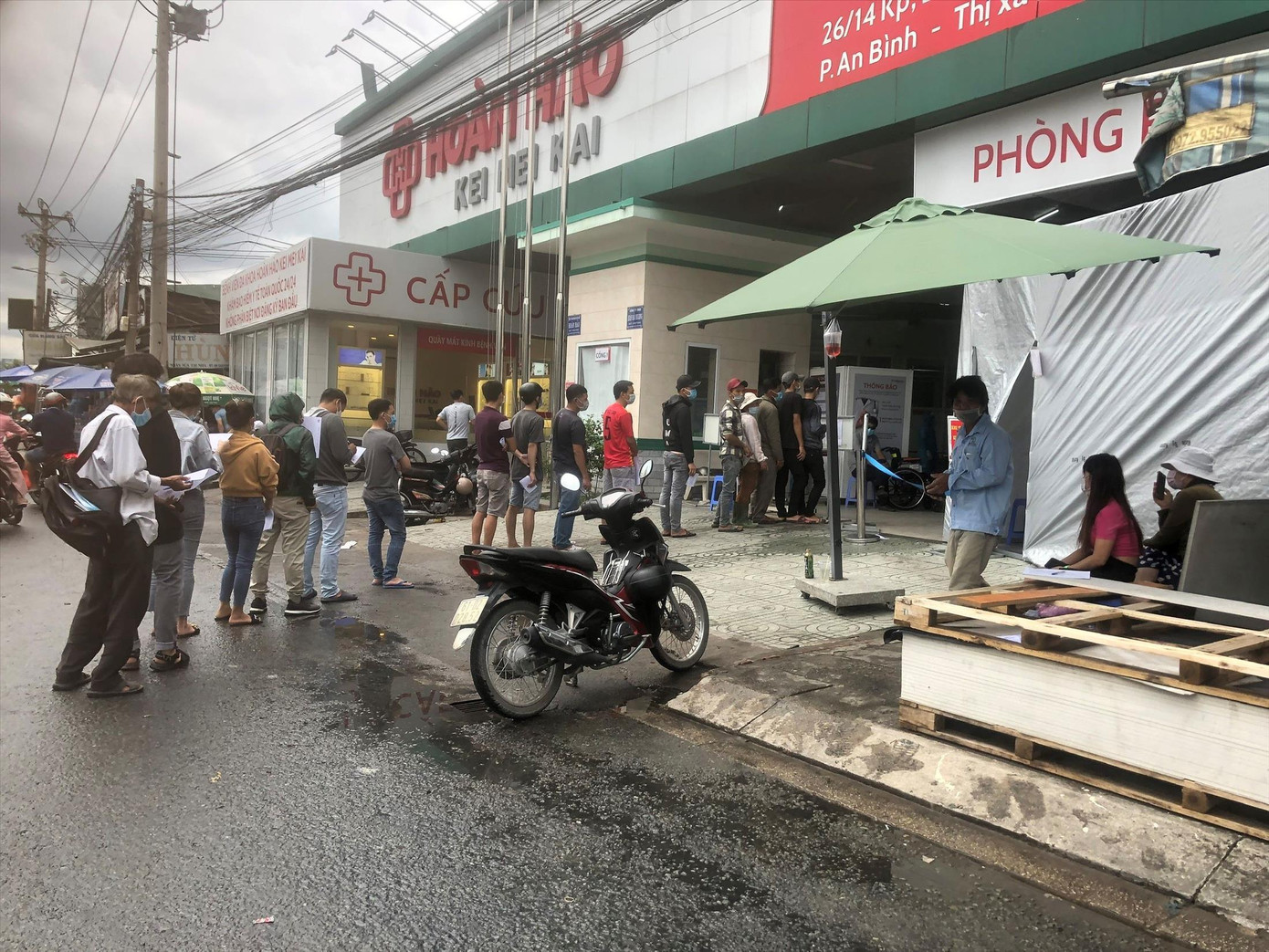 Người dân ở Bình Dương đội mưa chờ xét nghiệm COVID-19. Ảnh: Hương Chi