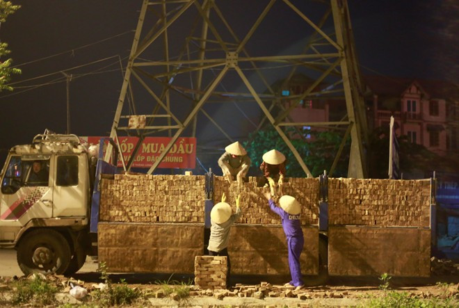 Trên đại lộ Thăng Long những công nhân làm thời vụ đang tích cực dỡ gạch từ một xe ô tô xuống dưới đất. Họ kiếm được 100.000 đồng/ người trong 2 giờ làm việc