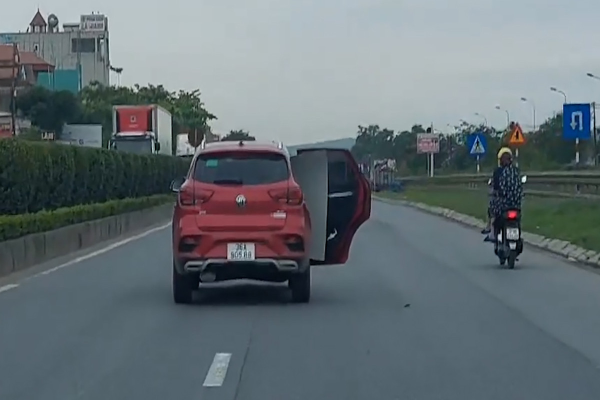 Ô tô mở cửa xe đi trên đường. Ảnh cắt từ video