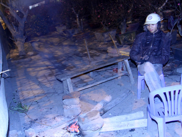 Một người trông đào đốt lửa sưởi ấm 