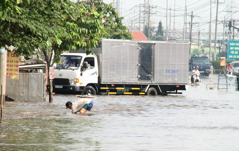 Người đàn ông này căm cụi hốt từng cụm rác để dòng chảy được thông suốt. Người đàn ông này căm cụi hốt từng cụm rác để dòng chảy được thông suốt