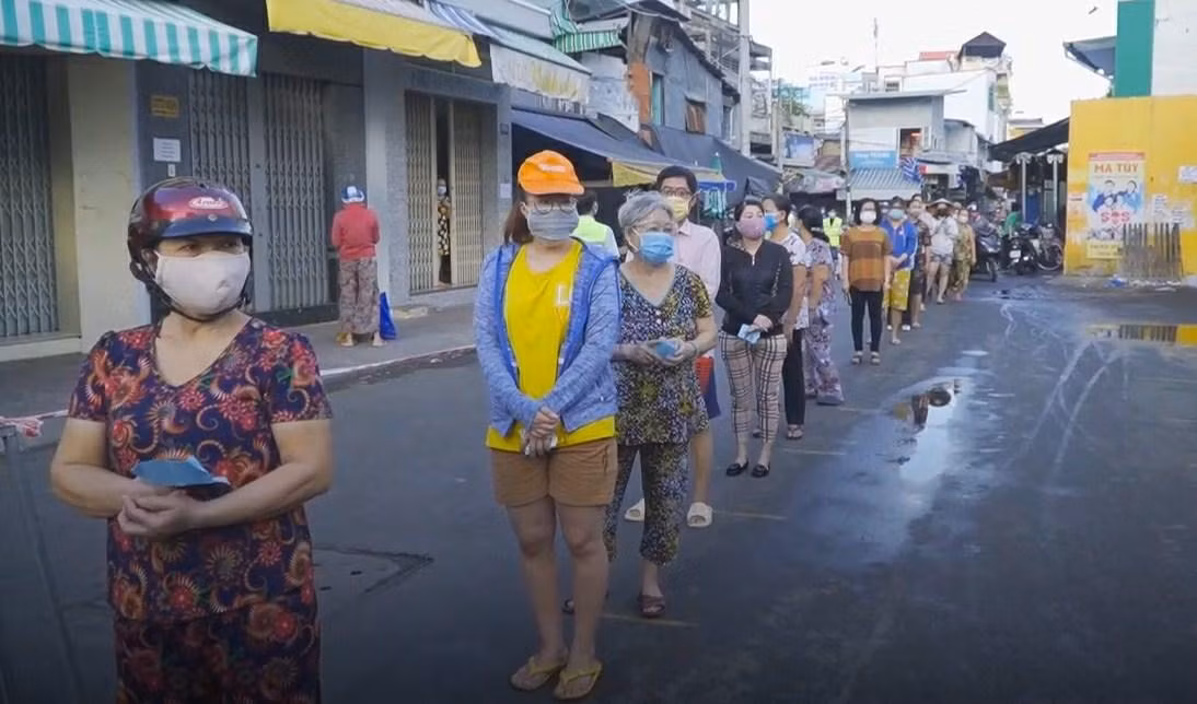 Người dân xếp hàng vào chợ Bình Thới (quận 11) mua lương thực, thực phẩm thiết yếu bằng phiếu đi chợ