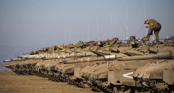 Một binh lính của Israel đang đứng ở trên dàn xe tăng vừa triển khai đối phó với Syria 