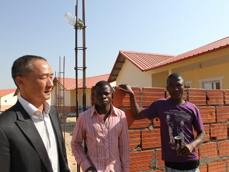 Anh Đức (người mặc vest) và khu căn hộ cho cán bộ công nhân viên quân khu Huambo do công ty anh xây dựng