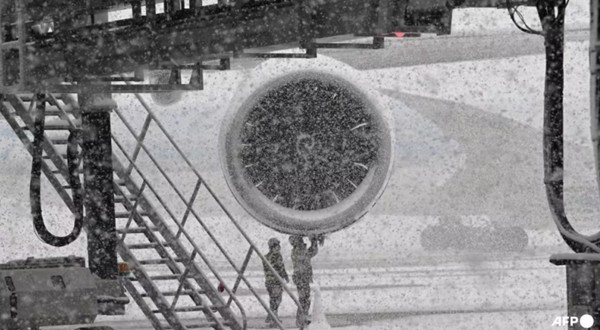 Máy bay của Korean Air đậu ở Sân bay Quốc tế Incheon và đang được kiểm tra giữa lúc tuyết rơi dày. Ảnh: Jung Yeon-je/ AFP.