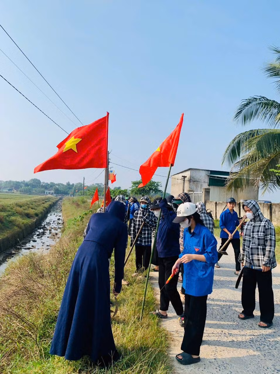 Sau khi dọn dẹp vệ sinh tuyến đường giao thông, các "áo xanh" còn tham gia hoạt động cắm cờ Tổ quốc, thể hiện tinh thần yêu nước và năng động của tuổi trẻ. Ảnh: Đoàn Trường THPT Thanh Chương 1