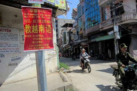 Quảng cáo dạy tiếng Trung, Việt hầu hết bằng chữ Trung Quốc trên một con phố thuộc phường Đồng Kỵ