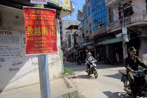 Quảng cáo dạy tiếng Trung, Việt hầu hết bằng chữ Trung Quốc trên một con phố thuộc phường Đồng Kỵ