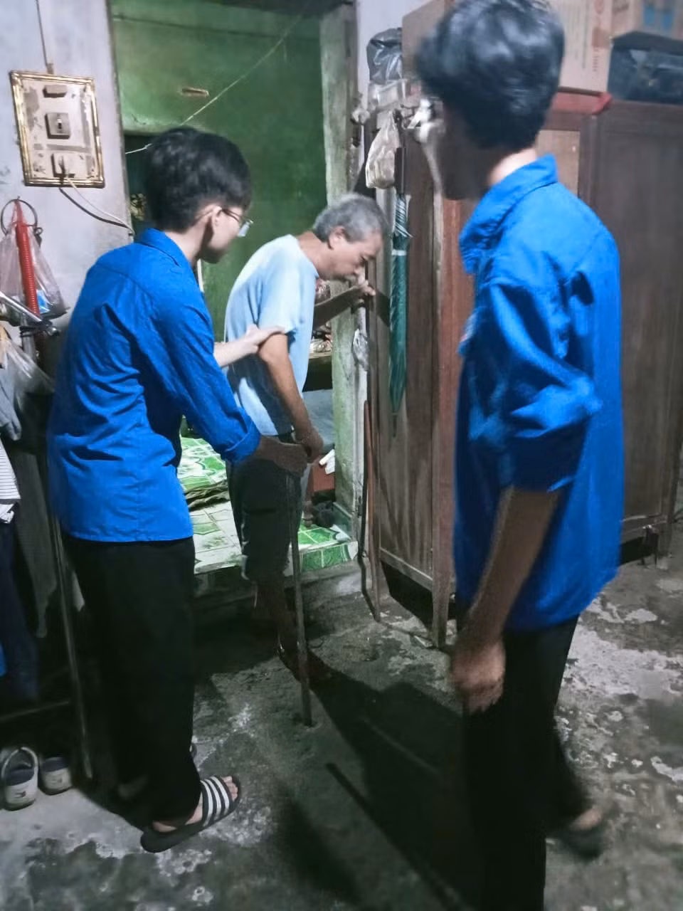 Đoàn viên thanh niên hỗ trợ gia đình có người lớn tuổi di chuyển đến nơi tránh trú bão Ảnh: Đoàn Phường Ngọc Sơn