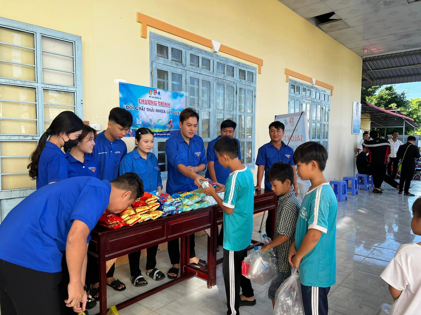 Các bạn đoàn viên trực tiếp thu gom, phân loại rác thải nhựa của các em thiếu nhi mang đến và tặng cho các em những phần quà. Ảnh: Thanh Niên Xã Mỹ An Hưng A